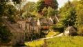 Charming English village with stone cottages, lush greenery, and winding paths, perfect for scenic exploration.
