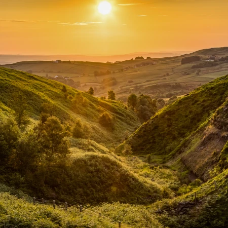 A tranquil sunset over rolling green hills, showcasing the natural beauty of the UK countryside, ideal for small group tours.