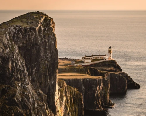 a lighthouse on a cliff in front of the ocean