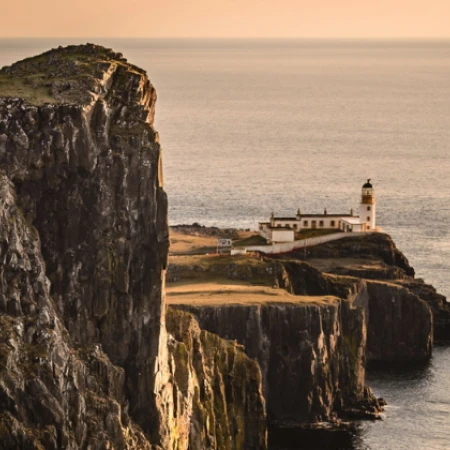 a lighthouse on a cliff in front of the ocean