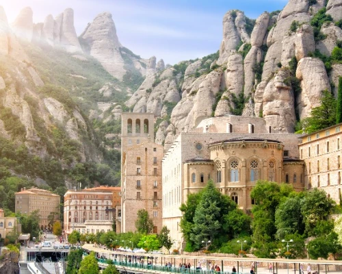Scenic view of a historic building nestled among towering rocky mountains, showcasing natural beauty and architectural elegance.