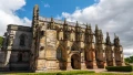 Stunning view of a historic stone church with intricate architecture under a blue sky with scattered clouds.